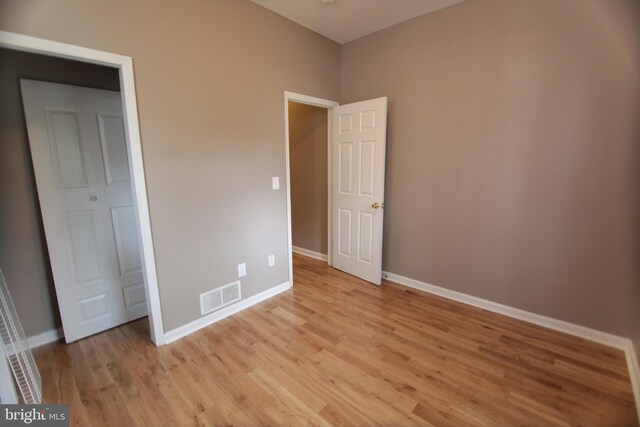 unfurnished bedroom featuring light hardwood / wood-style floors and a closet