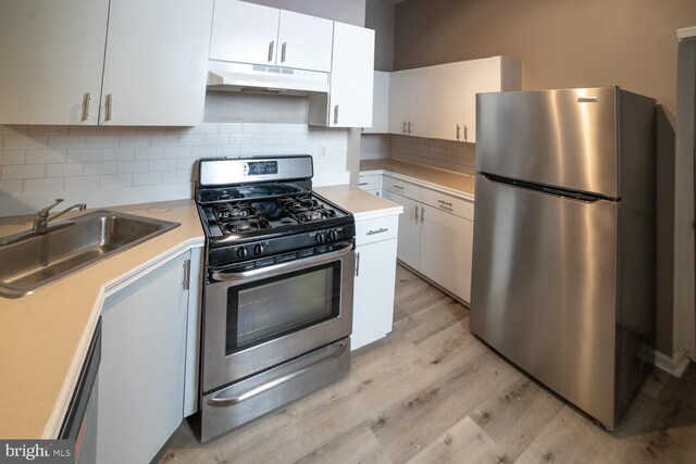 kitchen with sink, white cabinets, light hardwood / wood-style floors, and appliances with stainless steel finishes