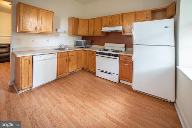 kitchen featuring light wood-type flooring, white appliances, and sink