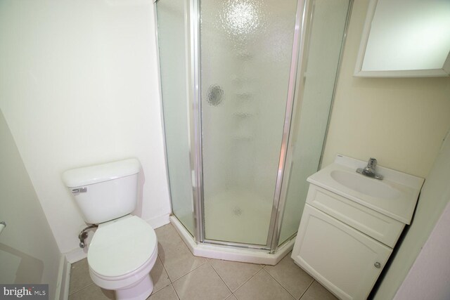 bathroom with tile patterned floors, vanity, an enclosed shower, and toilet