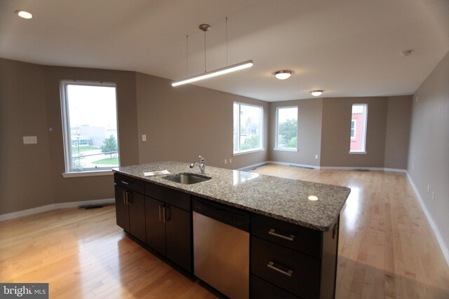 kitchen with a kitchen island with sink, dishwasher, plenty of natural light, and light wood-type flooring