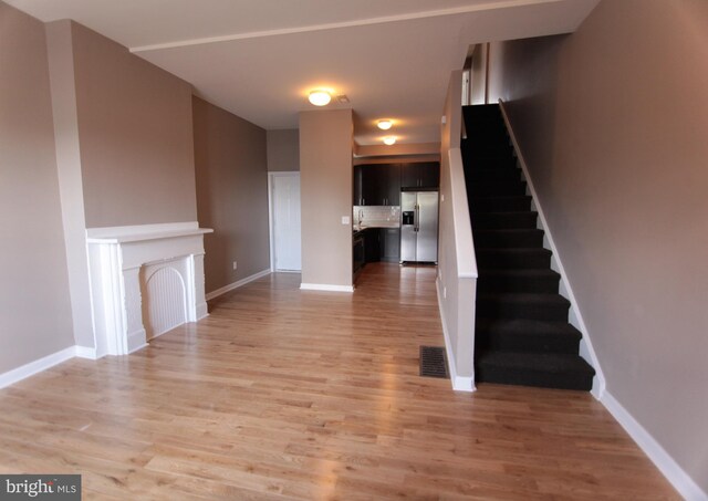 unfurnished living room featuring light wood-type flooring and a fireplace