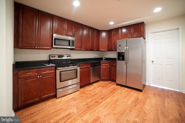 kitchen featuring sink, appliances with stainless steel finishes, and light hardwood / wood-style flooring