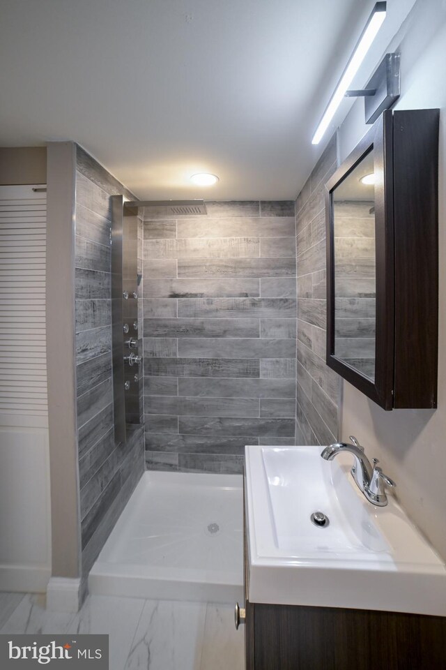 bathroom with vanity and tiled shower