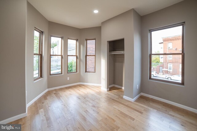 unfurnished bedroom featuring a closet and light hardwood / wood-style floors