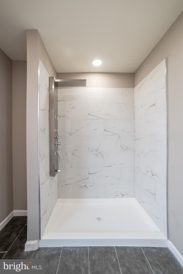 bathroom featuring tile patterned flooring and tiled shower