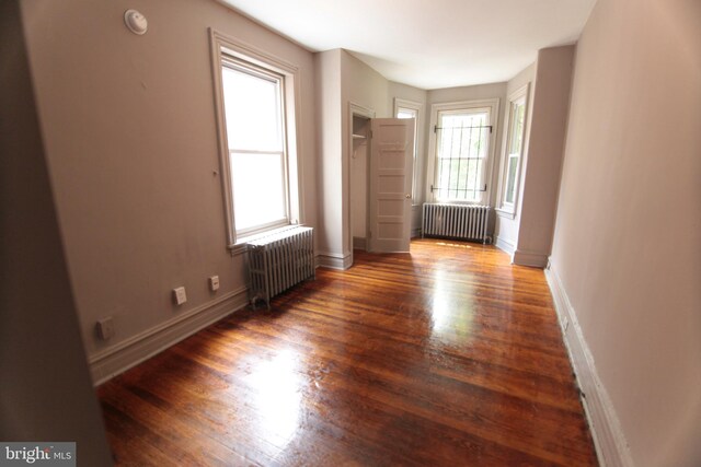 spare room with radiator and dark hardwood / wood-style floors