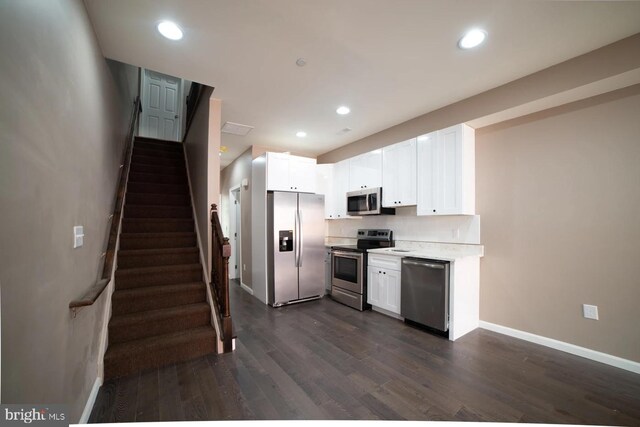 kitchen with white cabinets, dark wood-type flooring, and appliances with stainless steel finishes