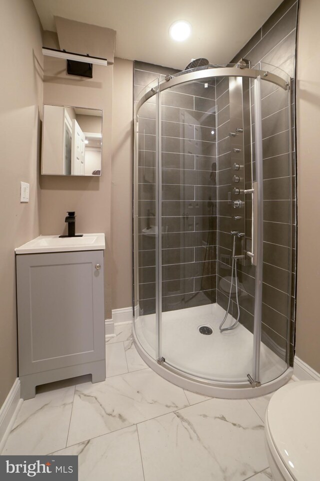 bathroom featuring vanity, toilet, and a shower with shower door