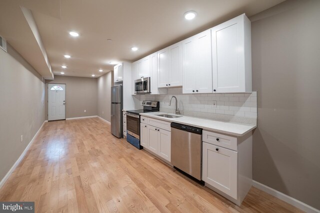 kitchen featuring light hardwood / wood-style flooring, white cabinets, and stainless steel appliances