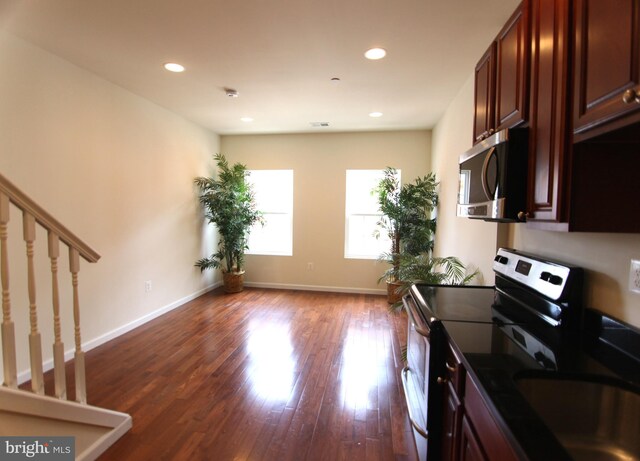 kitchen with appliances with stainless steel finishes and dark hardwood / wood-style floors