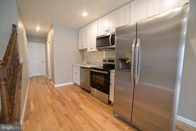 kitchen featuring sink, white cabinets, light wood-type flooring, and appliances with stainless steel finishes