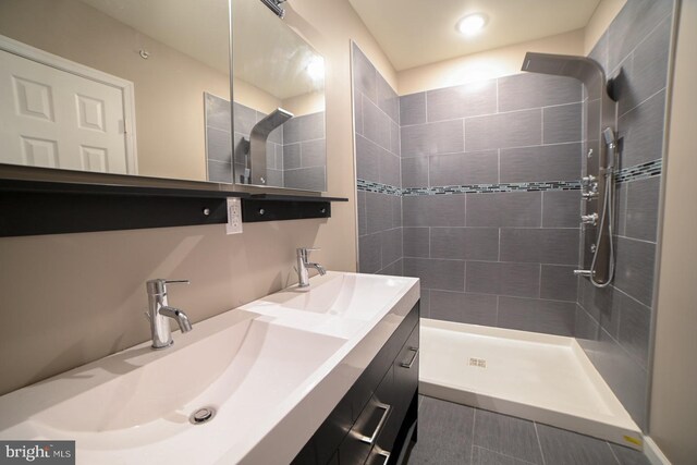 bathroom featuring a tile shower, tile patterned floors, and vanity