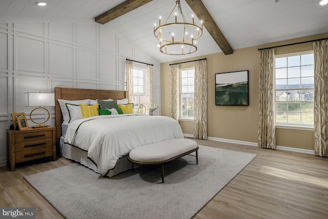 bedroom featuring a chandelier, light hardwood / wood-style flooring, and lofted ceiling with beams