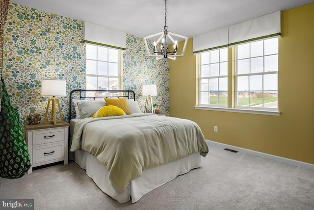 carpeted bedroom with multiple windows and a chandelier