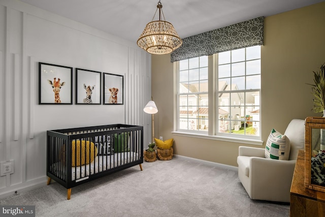 bedroom with carpet flooring, a chandelier, and a nursery area