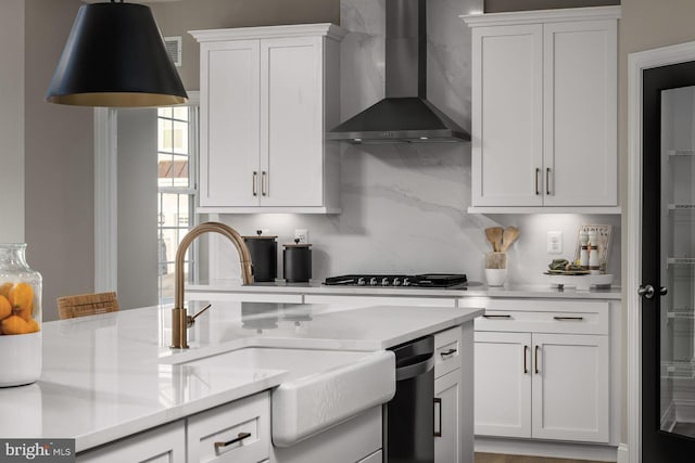 kitchen featuring backsplash, sink, wall chimney range hood, dishwasher, and white cabinetry