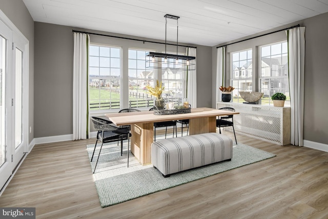 dining room featuring a chandelier, a healthy amount of sunlight, wood ceiling, and light hardwood / wood-style flooring