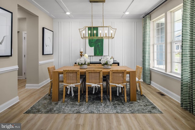 dining space featuring light wood-type flooring and a notable chandelier