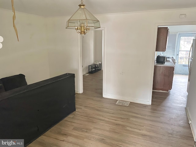 dining area with a chandelier, light wood-style flooring, and baseboards