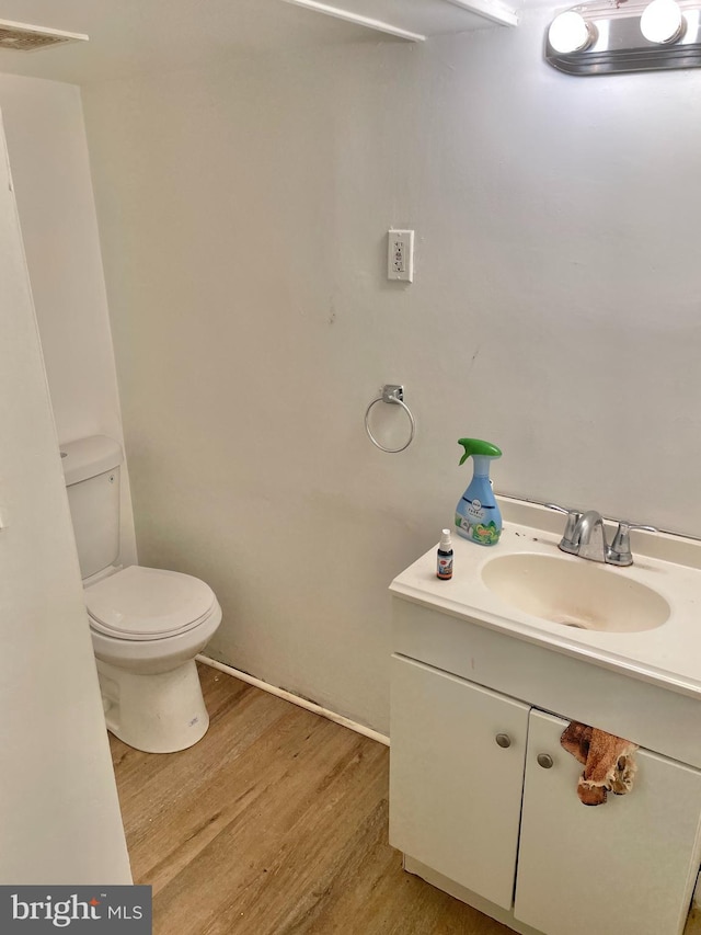 bathroom featuring hardwood / wood-style flooring, vanity, and toilet