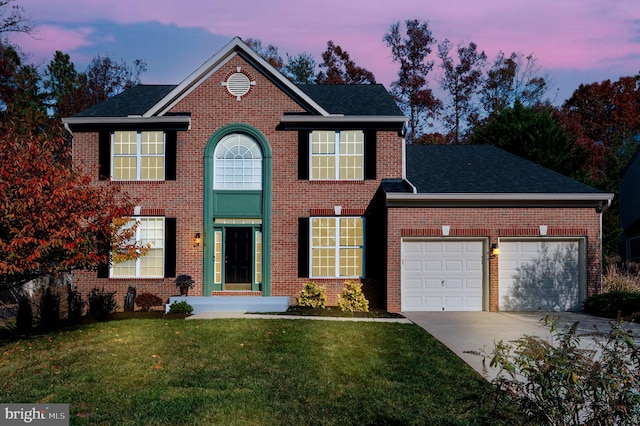 view of front of house with a garage and a lawn