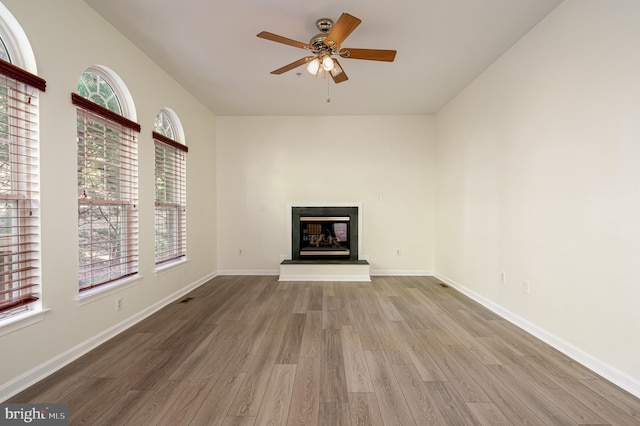 unfurnished living room featuring ceiling fan and hardwood / wood-style flooring