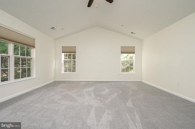 empty room featuring light carpet, ceiling fan, and vaulted ceiling