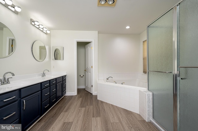 bathroom with vanity, wood-type flooring, and shower with separate bathtub