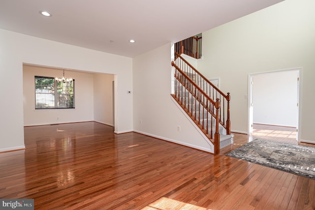 unfurnished room with wood-type flooring and a chandelier