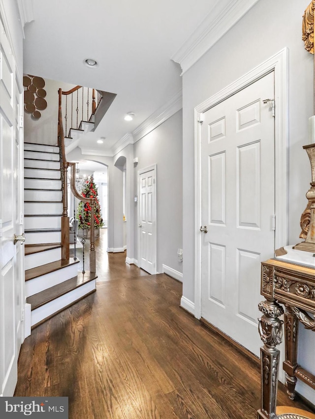 entrance foyer with dark hardwood / wood-style floors and ornamental molding