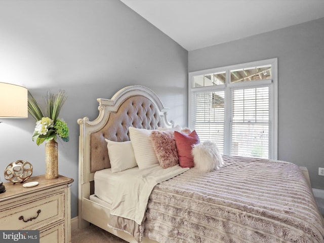 carpeted bedroom featuring lofted ceiling