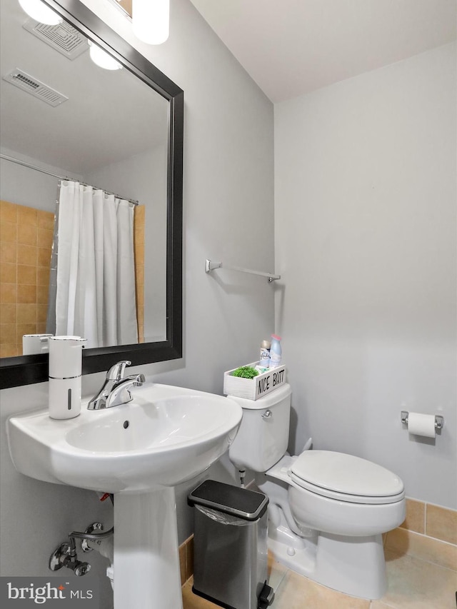 bathroom with tile patterned floors, a shower with curtain, and toilet