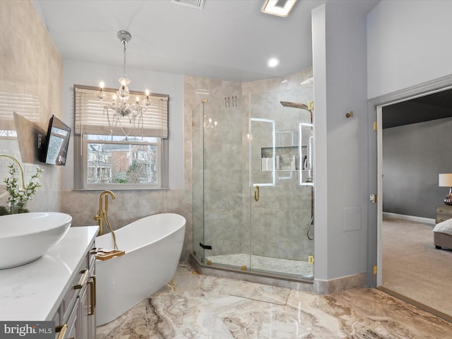 bathroom featuring vanity, separate shower and tub, and an inviting chandelier