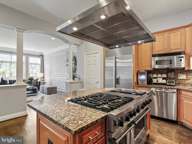 kitchen featuring decorative columns, island range hood, dark hardwood / wood-style floors, and high end appliances