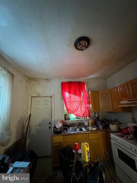 kitchen featuring white stove and sink