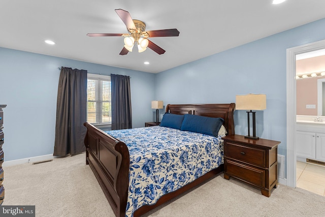 carpeted bedroom with ensuite bath, ceiling fan, and sink