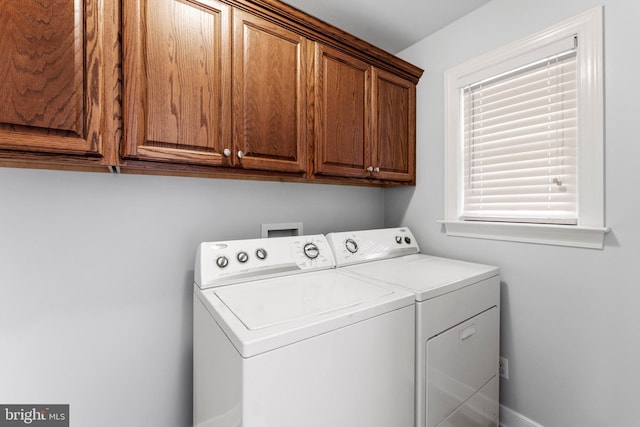 laundry area featuring washer and clothes dryer and cabinets