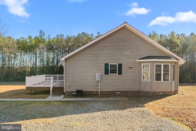 view of property exterior with a deck and a yard