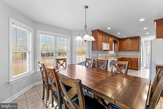 dining area with sink, light tile patterned floors, and a notable chandelier