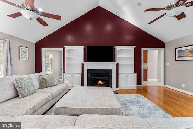 living room with ceiling fan, high vaulted ceiling, and light wood-type flooring