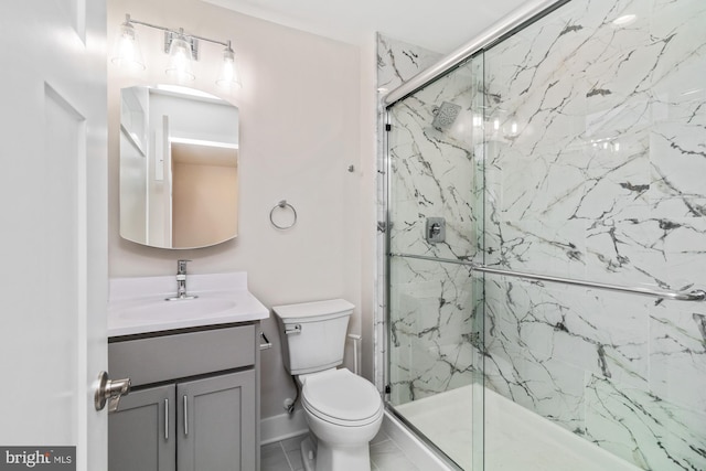 bathroom featuring a shower with door, vanity, and toilet