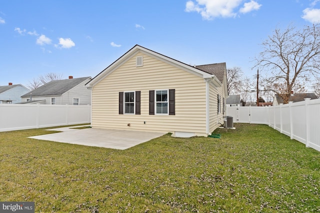 back of house featuring central air condition unit, a lawn, and a patio