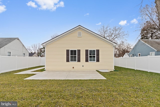 back of property with a yard and a patio