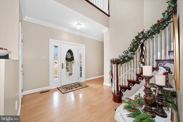 foyer entrance featuring hardwood / wood-style flooring and crown molding