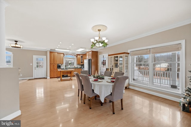 dining space featuring plenty of natural light, a notable chandelier, and ornamental molding