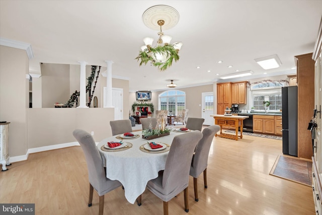 dining area with light wood-type flooring and ornamental molding