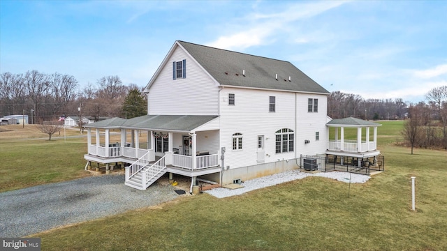 back of house featuring central AC unit, a porch, and a lawn