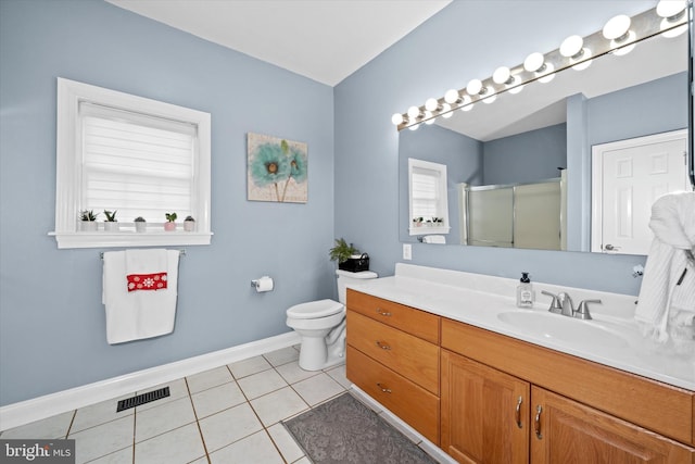 bathroom with tile patterned flooring, vanity, a shower with shower door, and toilet