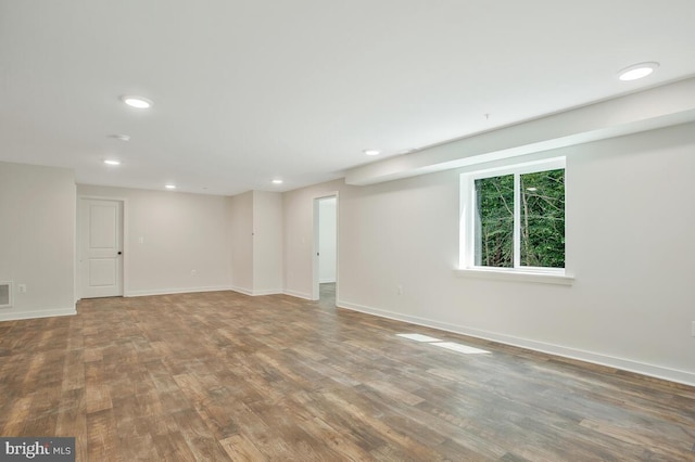 below grade area with recessed lighting, visible vents, baseboards, and wood finished floors